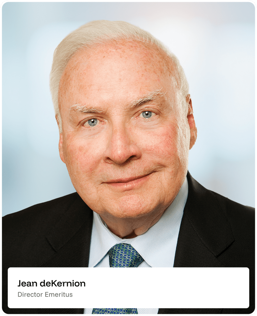 An older man with white hair in a suit and tie, smiling slightly, is shown in a professional headshot. A label below reads Jean deKernion, Director Emeritus. The background is softly blurred.
