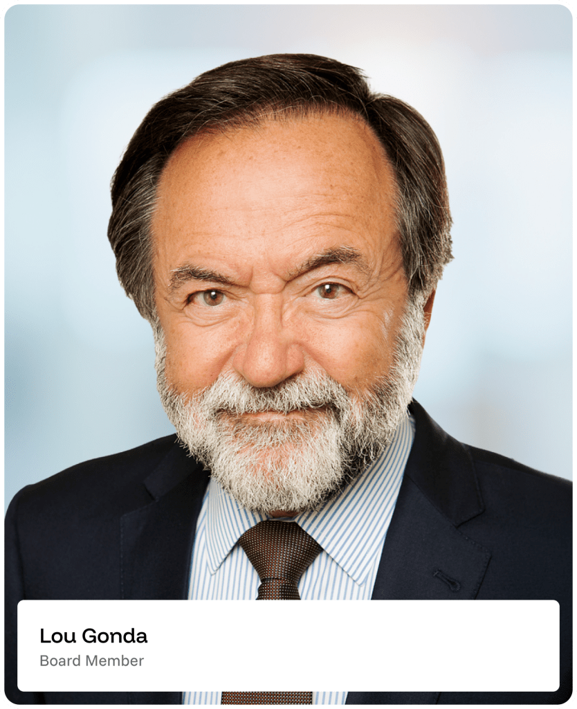 A smiling older man with gray hair and a beard, wearing a dark suit, striped shirt, and brown tie, stands in front of a softly blurred background. A label reads Lou Gonda, Board Member..